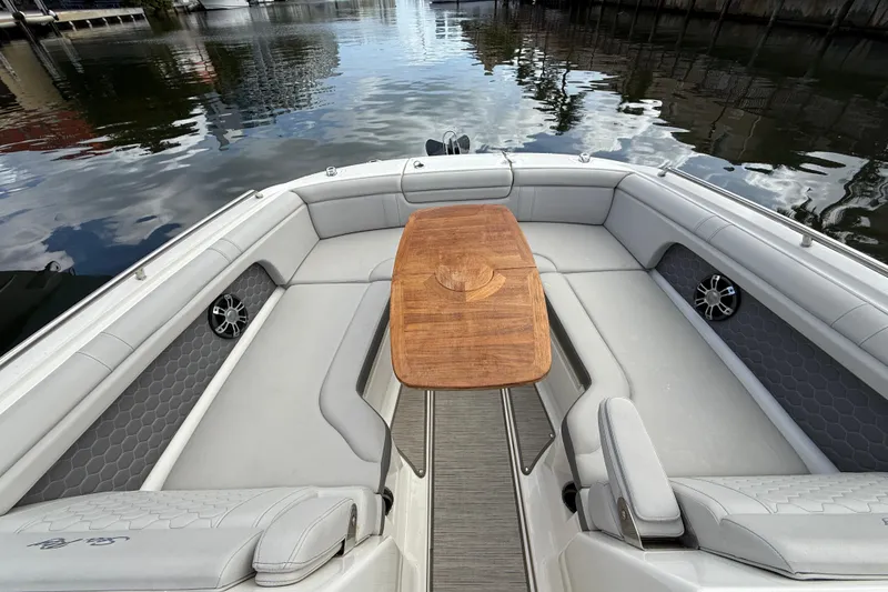 Slide: The Image of 2021 Sea Ray SDX 290 Outboard boat interior with wooden table and cushioned seating. - 26