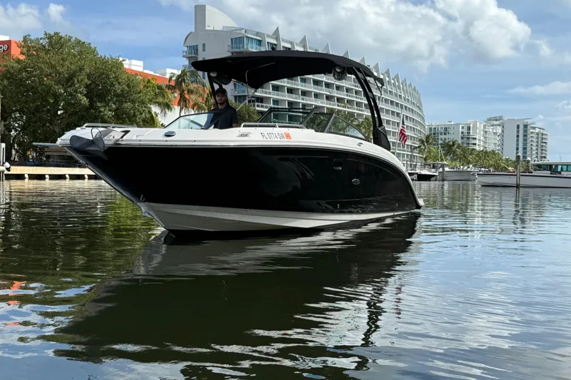 Slide: The Image of 2021 Sea Ray SDX 290 Outboard boat on water, modern buildings in background. - 3