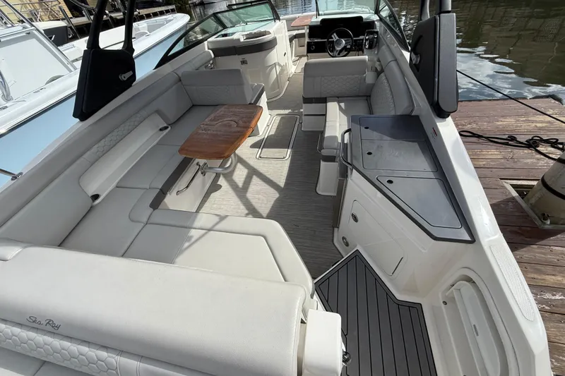 Slide: The Image of 2021 Sea Ray SDX 290 Outboard boat interior with seating and wooden table. - 31