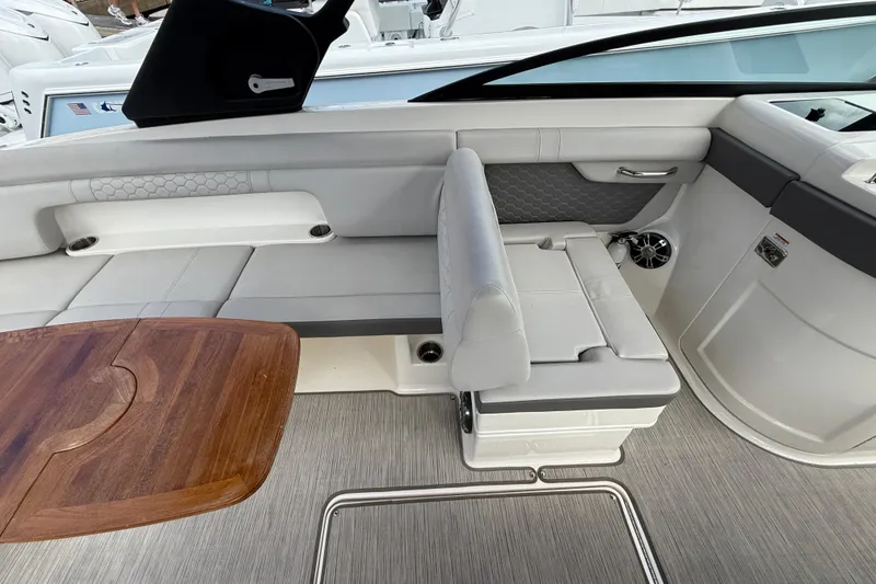 Slide: The Image of 2021 Sea Ray SDX 290 Outboard interior with sleek seating and wooden table. - 35
