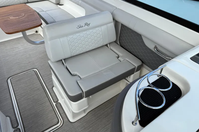 Slide: The Image of 2021 Sea Ray SDX 290 Outboard interior with gray seating and wooden table. - 38