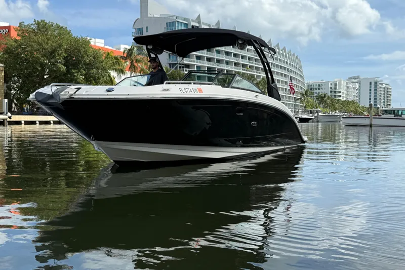 Slide: The Image of 2021 Sea Ray SDX 290 Outboard boat on water, with modern buildings in the background. - 4