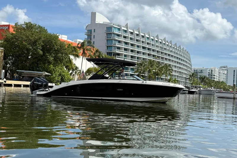 Slide: The Image of 2021 Sea Ray SDX 290 Outboard boat on calm water near modern buildings. - 6