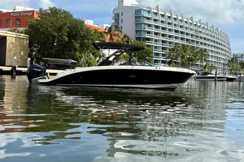 Slide: The Image of 2021 Sea Ray SDX 290 Outboard boat docked near modern waterfront buildings. - 8