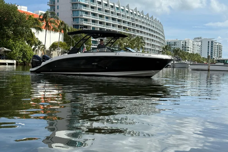 Slide: The Image of 2021 Sea Ray SDX 290 Outboard boat on water near modern buildings and palm trees. - 9