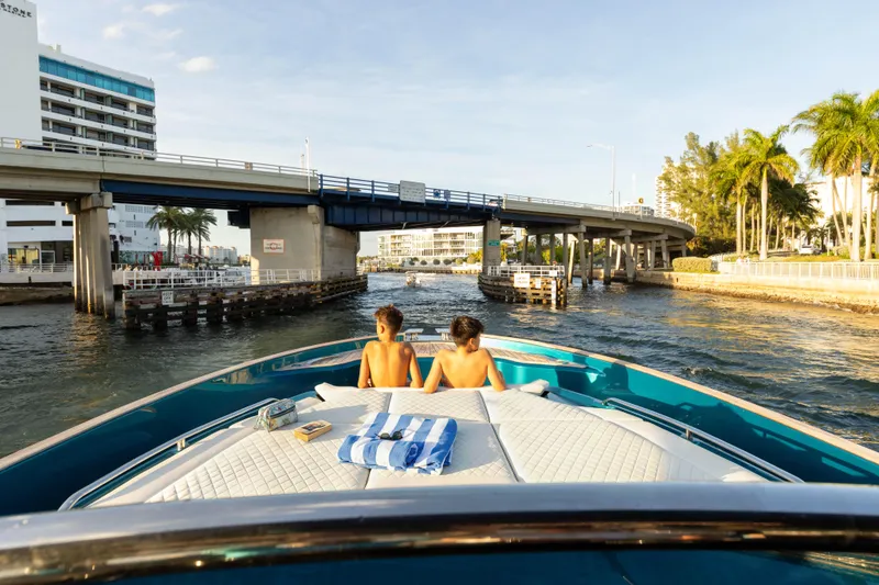 Slide: The Image of 2024 Solaris Power 52 Open yacht cruising under a bridge with two people relaxing onboard. - 16