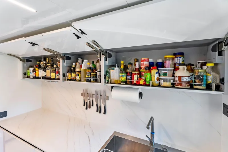 Slide: The Image of Modern yacht kitchen with open cabinets, condiments, knives, and sleek design on 2020 Ferretti Yachts 920. - 38