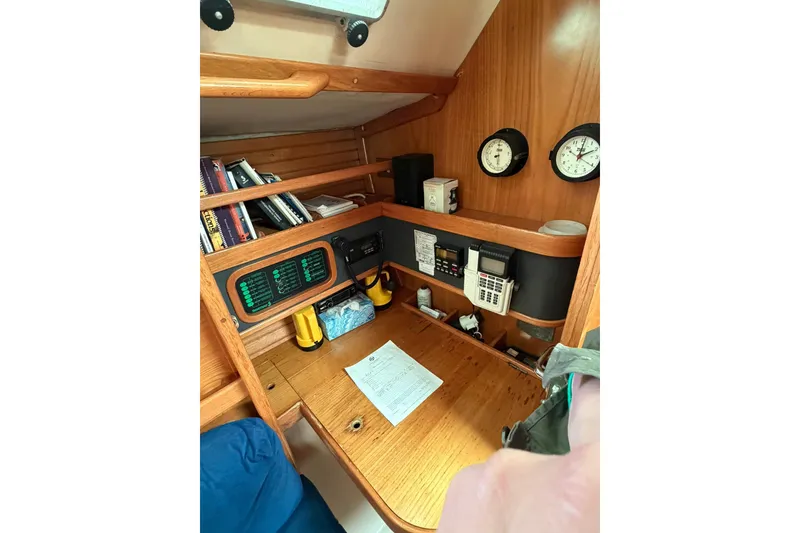 Slide: The Image of Navigation station inside 1990 Beneteau Oceanis 430 sailboat with instruments and books. - 7