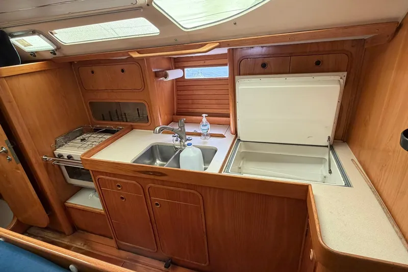 Slide: The Image of Interior view of 1990 Beneteau Oceanis 430 yacht kitchen with wooden cabinetry and appliances. - 9
