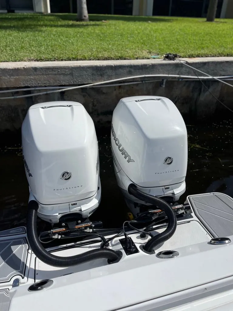 Slide: The Image of 2019 Blackfin 272 CC boat with twin Mercury outboard engines docked by green lawn. - 6
