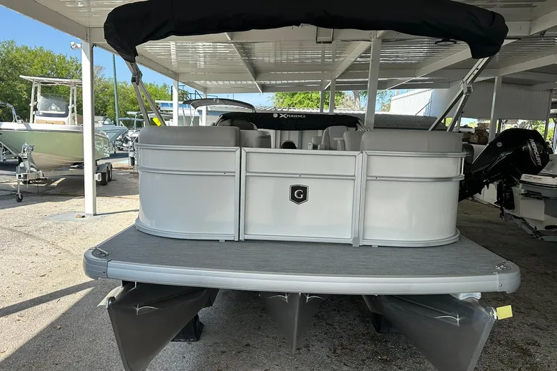 Slide: The Image of 2026 Sweetwater EX2286SBX pontoon boat under a covered dock. - 2