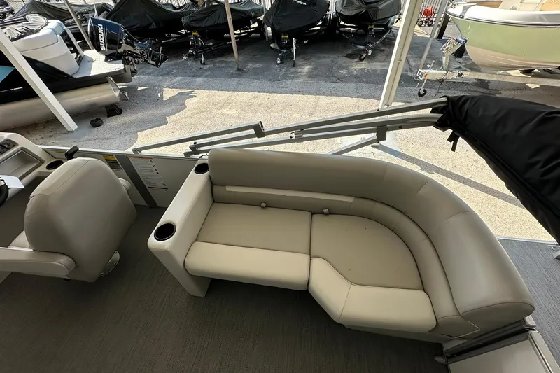 Slide: The Image of Interior of 2026 Sweetwater EX2286SBX pontoon boat with beige seating and cup holders. - 24