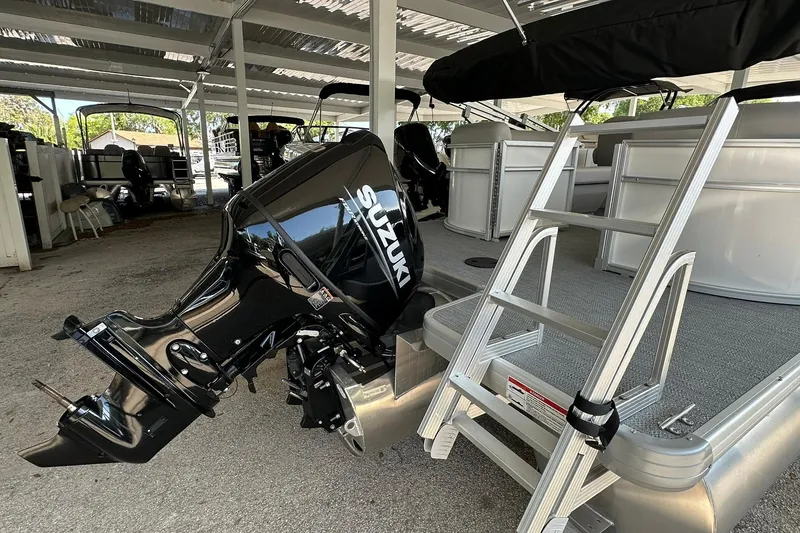 Slide: The Image of 2026 Sweetwater EX2286SBX pontoon boat with Suzuki outboard motor and boarding ladder. - 29