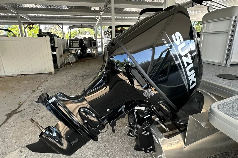 Slide: The Image of Suzuki outboard motor on Sweetwater EX2286SBX boat, 2026 model, in a covered storage area. - 30