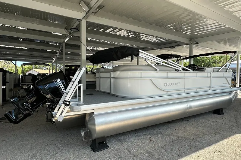 Slide: The Image of 2026 Sweetwater EX2286SBX pontoon boat with Suzuki motor under covered storage. - 32
