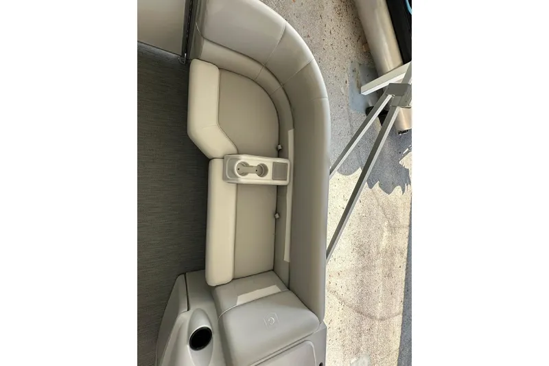 Slide: The Image of 2026 Sweetwater EX2286SBX boat interior with beige seating and cup holder. - 7