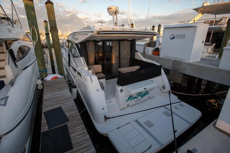 Slide: The Image of 2018 Sea Ray Sundancer 400 docked at marina, rear view with open deck. - 20