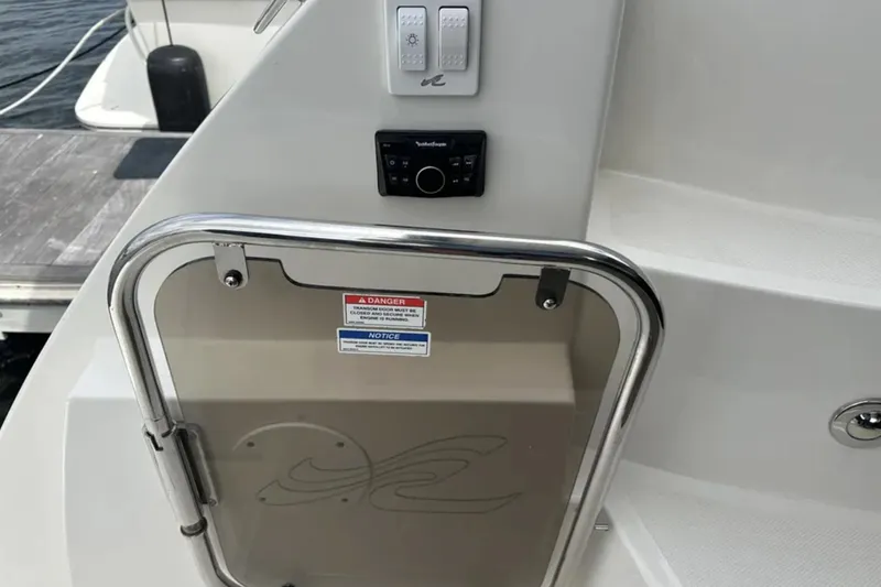 Slide: The Image of 2018 Sea Ray Sundancer 400 boat door with control panel and safety notices. - 4