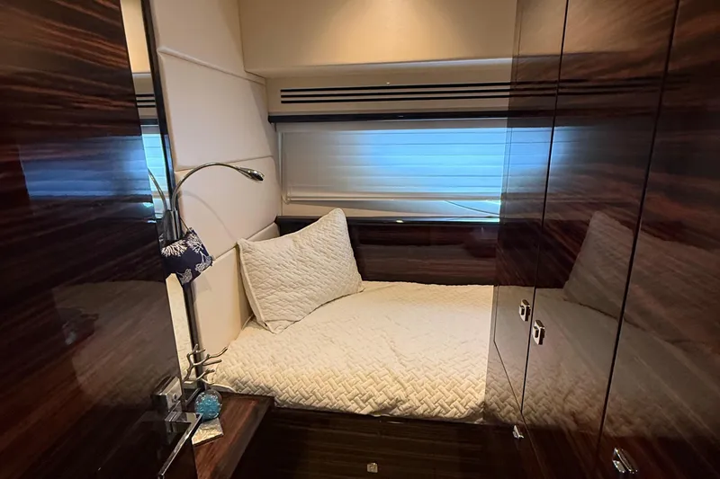 Slide: The Image of Luxurious cabin interior of a 2014 Hampton Fly yacht with cozy bedding and wood paneling. - 27