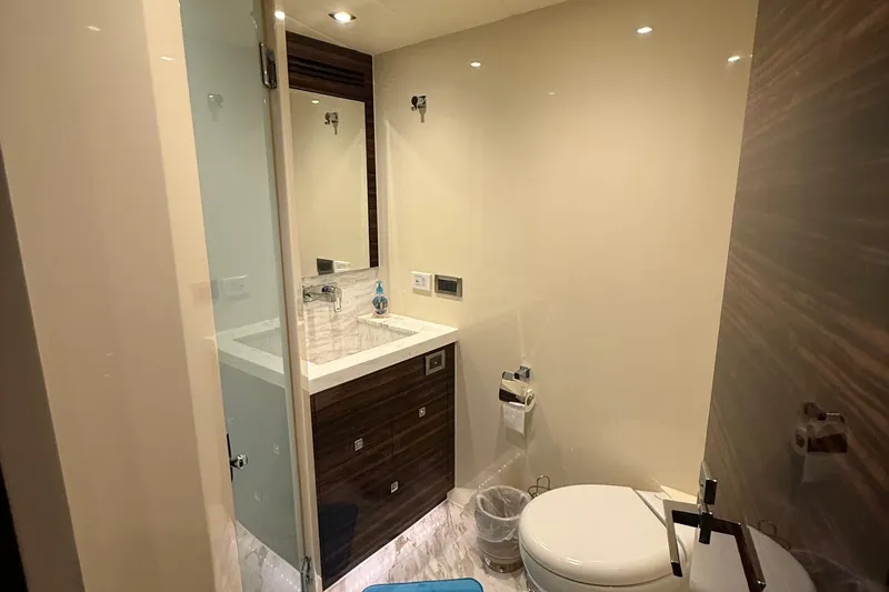 Slide: The Image of Modern yacht bathroom with sink, toilet, and mirror in a 2014 Hampton Fly model. - 29