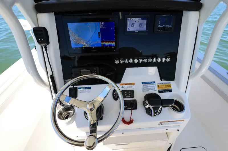 Slide: The Image of 2025 World Cat 235 TE boat dashboard with steering wheel and navigation screens. - 10