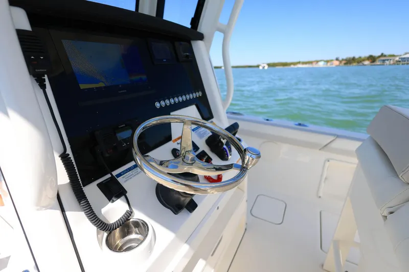 Slide: The Image of Interior view of 2025 World Cat 235 TE boat, featuring steering wheel and control panel. - 11