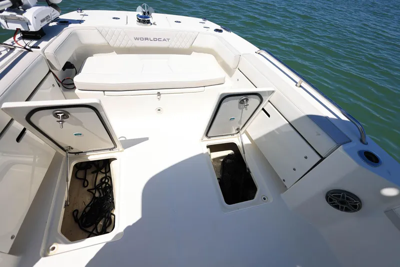 Slide: The Image of 2025 World Cat 235 TE boat deck with open storage compartments on the water. - 14