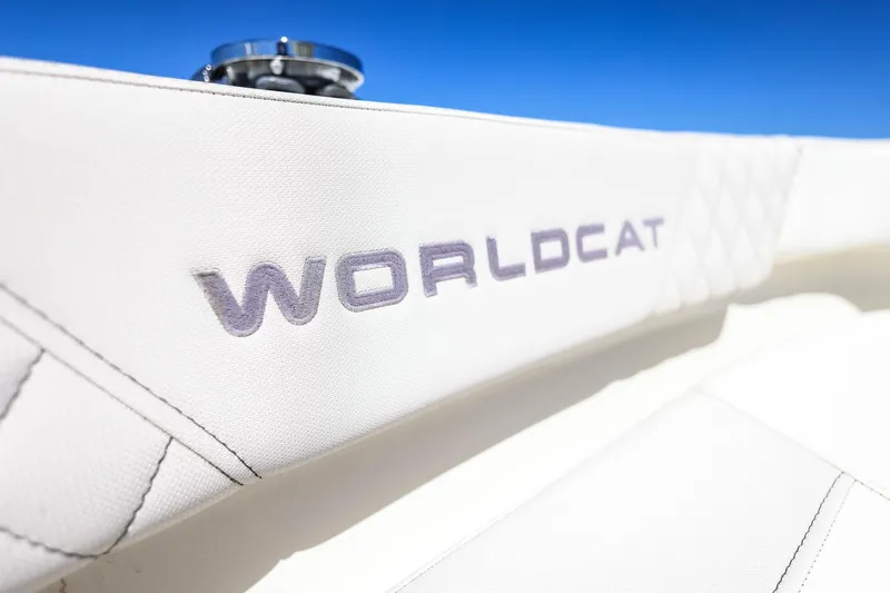 Slide: The Image of 2025 World Cat 235 TE boat interior with logo, featuring white upholstery and blue sky background. - 15