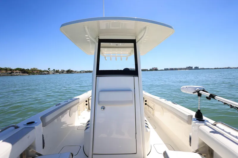 Slide: The Image of 2025 World Cat 235 TE boat on calm water under clear blue sky. - 17