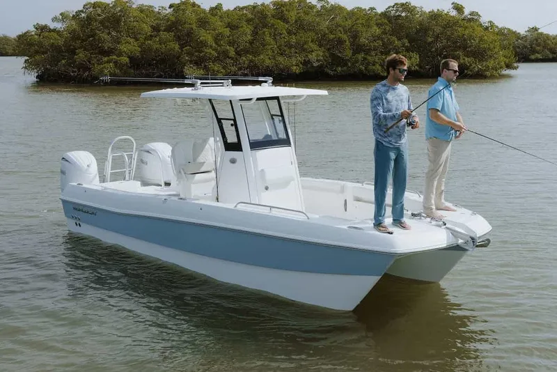 Slide: The Image of 2025 World Cat 235 TE boat on calm water under clear blue sky. - 2