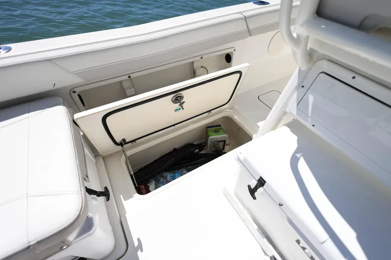 Slide: The Image of Storage compartment on 2025 World Cat 235 TE boat, open with items inside. - 7