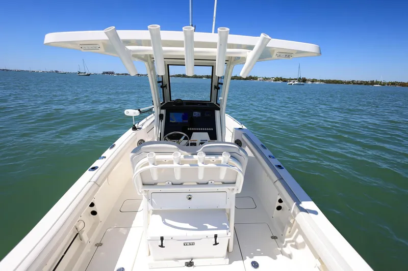 Slide: The Image of 2025 World Cat 235 TE boat on calm waters, featuring a spacious deck and modern helm. - 8