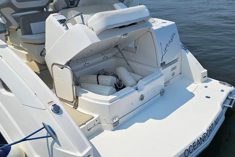 Slide: The Image of 2015 Chaparral 310 Signature boat with open storage compartment on deck. - 11