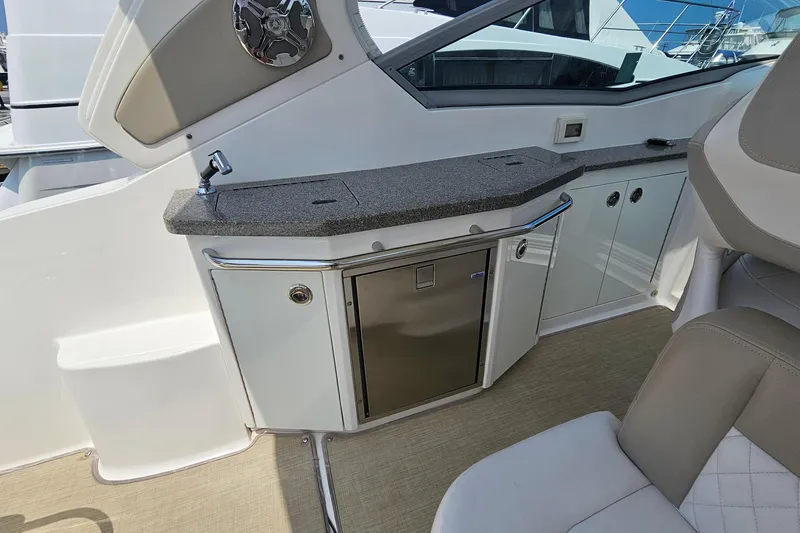 Slide: The Image of 2015 Chaparral 310 Signature boat interior with kitchenette, sink, and storage cabinets. - 15