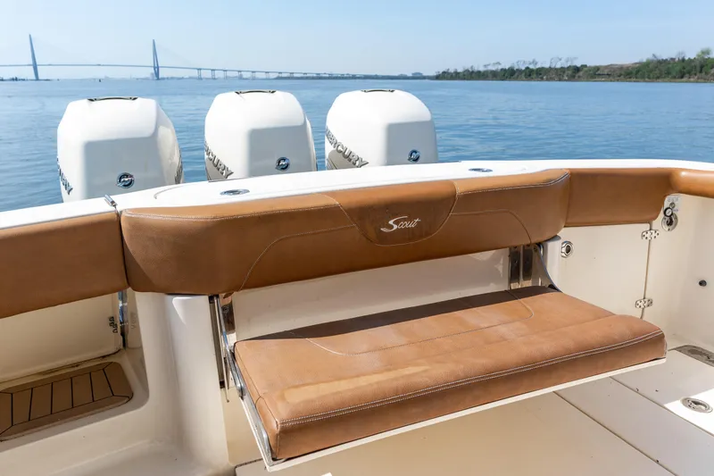 Slide: The Image of 2020 Scout 355 LXF boat with brown seating and triple Mercury engines on calm water. - 11