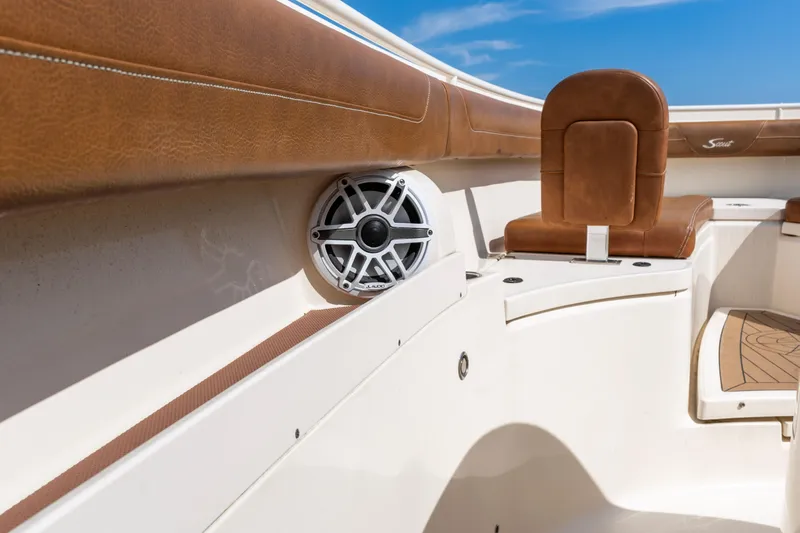 Slide: The Image of 2020 Scout 355 LXF boat interior with brown leather seating and speaker. - 12