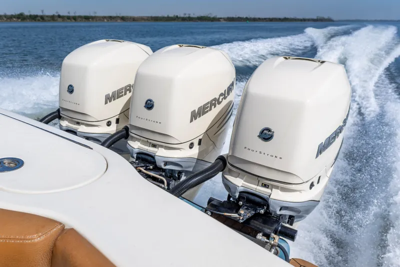 Slide: The Image of Triple Mercury outboard engines powering a 2020 Scout 355 LXF boat on open water. - 17