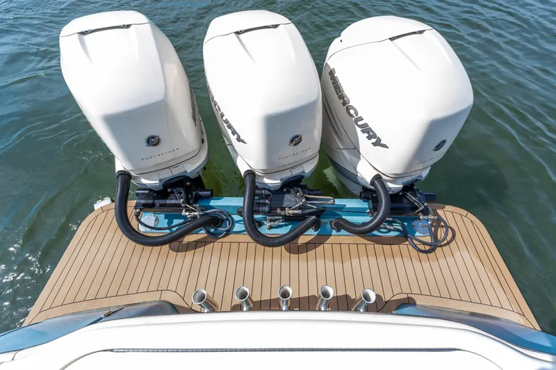 Slide: The Image of Triple Mercury outboard engines on 2020 Scout 355 LXF boat, docked on water. - 18