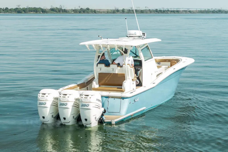 Slide: The Image of 2020 Scout 355 LXF boat with triple engines cruising on calm water. - 3