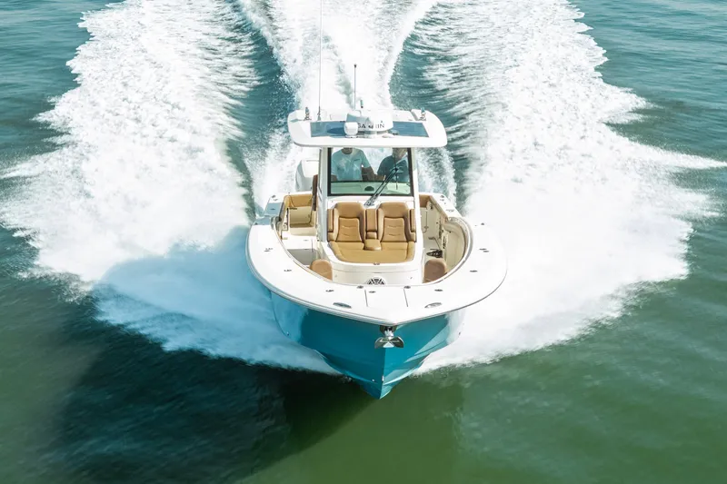 Slide: The Image of 2020 Scout 355 LXF boat cruising on open water, creating a dynamic wake. - 4