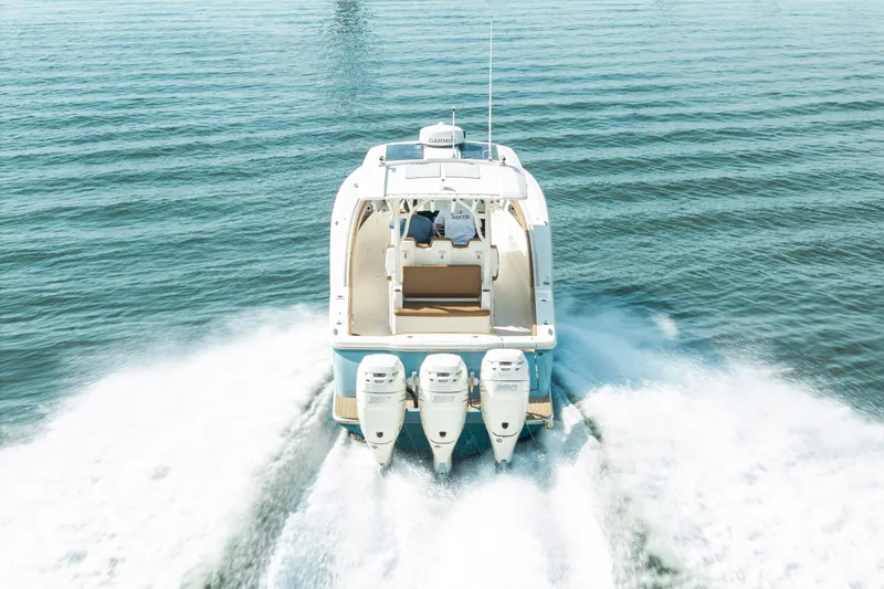 Slide: The Image of 2020 Scout 355 LXF boat cruising on open water, rear view. - 5