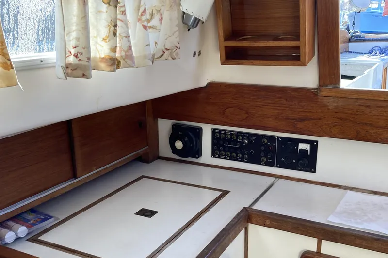 Slide: The Image of Interior of a 1971 Luders 33 sailboat with wood paneling and control panel. - 13