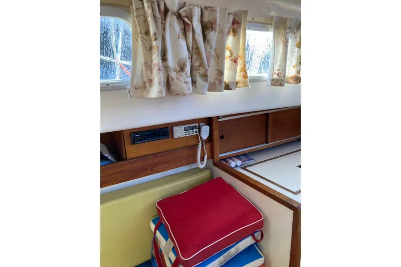 Slide: The Image of Interior of a 1971 Luders 33 sailboat with floral curtains and colorful cushions. - 14
