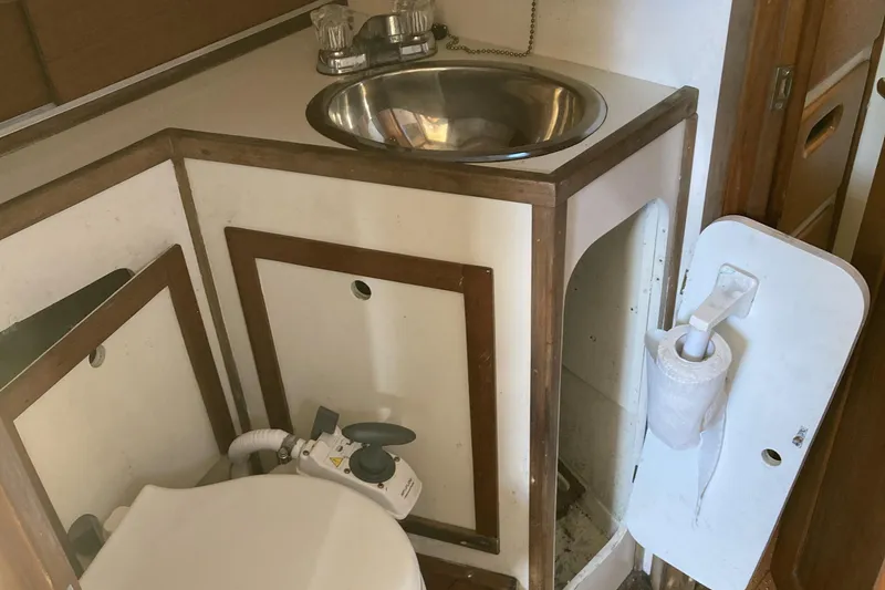 Slide: The Image of 1971 Luders 33 yacht bathroom with sink, toilet, and wooden cabinetry. - 16