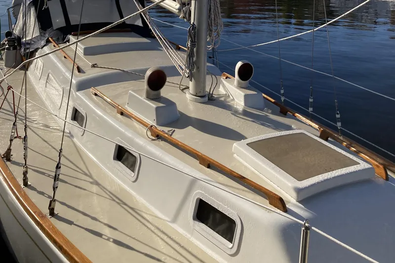 Slide: The Image of 1971 Luders 33 sailboat deck with wooden trim and rigging, docked on calm water. - 8