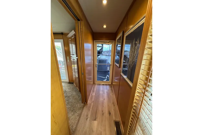 Slide: The Image of Narrow hallway in 2008 Starlite 18x85 houseboat with wooden flooring and framed artwork. - 16