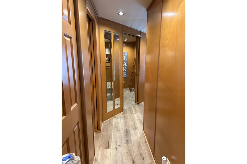 Slide: The Image of Narrow hallway in 2008 Starlite 18x85 houseboat with wooden paneling and mirrored doors. - 9