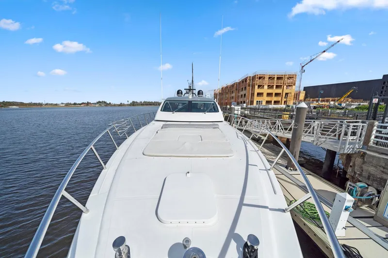 Slide: The Image of 2010 Mangusta 72 Express yacht docked by waterfront construction site. - 11