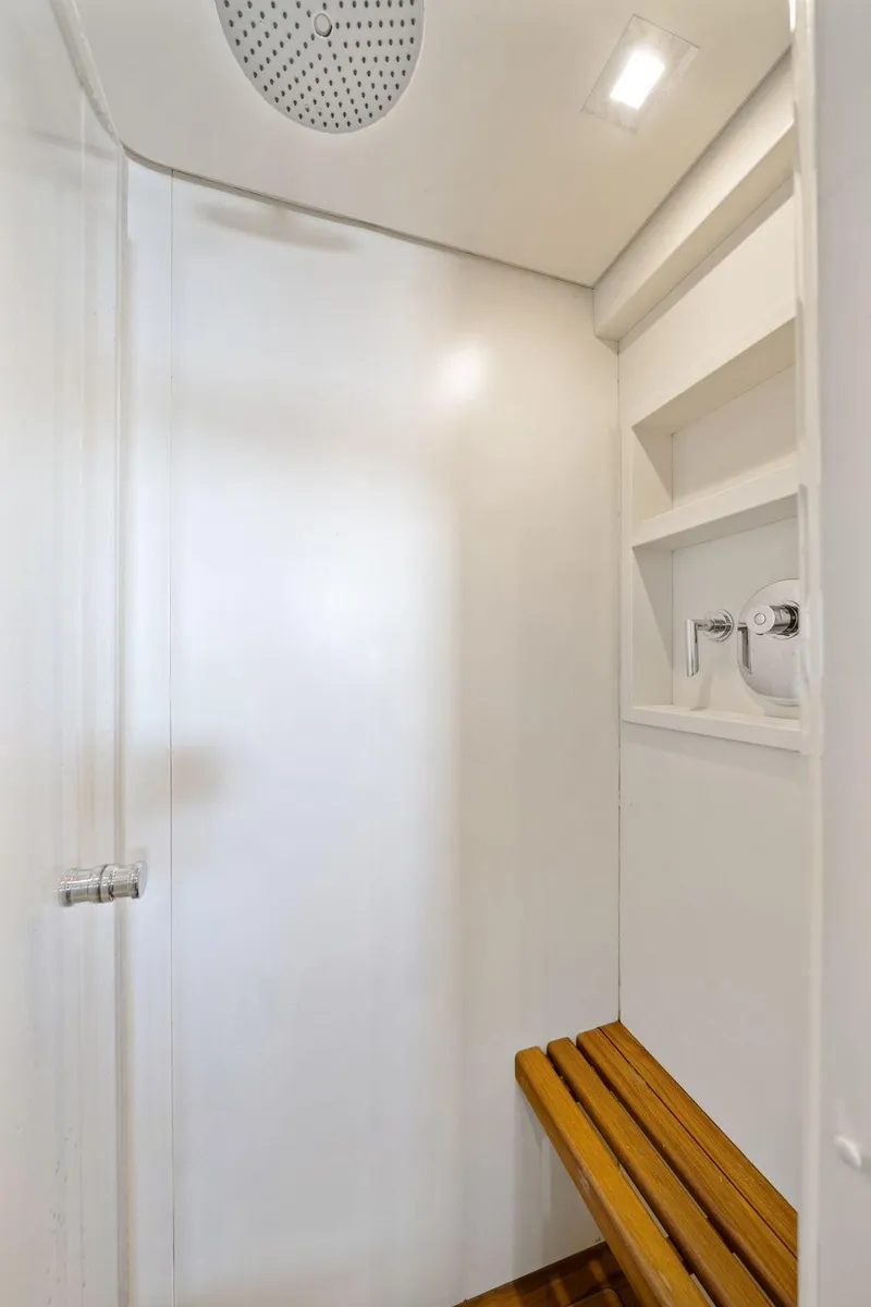 Slide: The Image of Shower area in 2010 Mangusta 72 Express yacht with wooden bench and modern fixtures. - 35