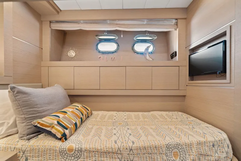 Slide: The Image of Luxurious cabin interior of 2010 Mangusta 72 Express yacht with cozy bed and porthole windows. - 45